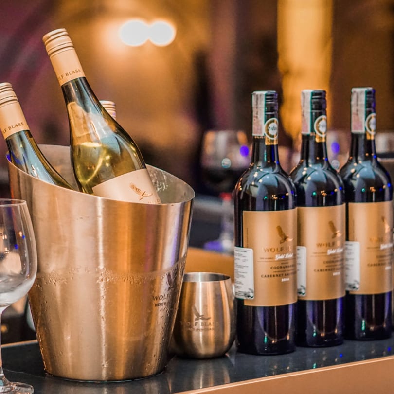 Wolf Blass wine bottles, white in an ice bucket and red on a shelf, at The Switch SLO.